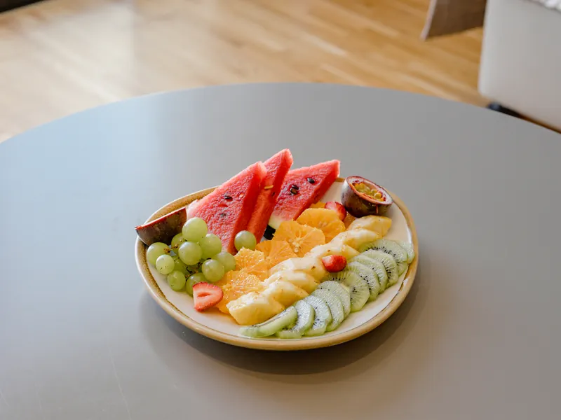 Platter of sliced seasonal fruit — watermelon, grapes, orange, kiwi and passion fruit